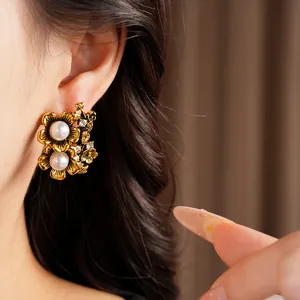 Detail shot of vintage gold floral stud earrings featuring pearls and rhinestones