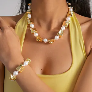 Close-up detail of vintage gold crinkled square and pearl necklace set worn on model