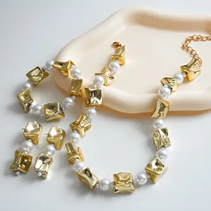 Detailed view of a vintage jewelry set featuring gold wrinkled square beads and white pearls