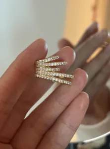 Detailed close-up showing sparkling cubic zirconia multi-layer gold ear cuff on fingers