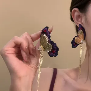 Detailed close-up of elegant purple and gold butterfly tassel earrings with zircon accents.