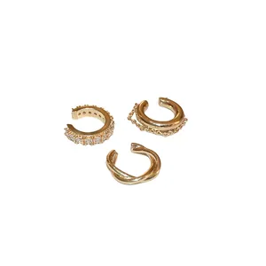 Set of three gold metal ear cuffs with zircon inlay and minimalist twisted design