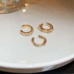 Premium set of three gold ear cuffs with cubic zirconia and twisted metal detailing