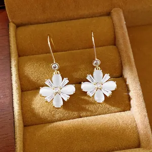 Nahaufnahme von Blumenohrringen mit Zirkon und Katzenauge in einer Schmuckschatulle