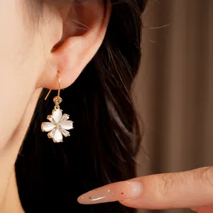 Nahaufnahme des detaillierten Ohrrings mit Zirkonia- und Katzenaugenstein-Blüten