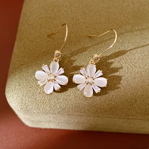 Nahaufnahme eleganter Blumenohrringe mit Katzenaugensteinen und glänzenden Zirkonia