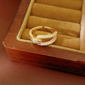 Detail of 18k gold plated open ring with zircon inlay and geometric hollow design
