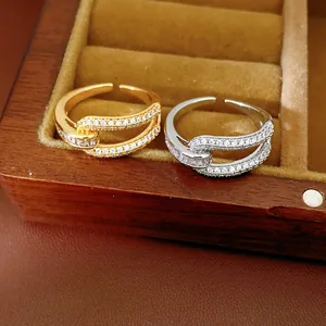 Detailed macro view of gold and silver plated geometric cutout rings with sparkling zircons.