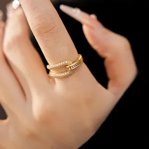 Detailed close-up of a gold-plated geometric hollow ring featuring sparkling cubic zirconia