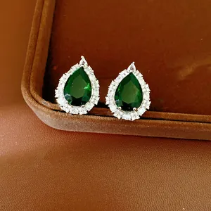 Elegant pear-cut green zircon stud earrings with sparkling halo setting detail view
