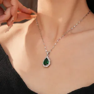 Close-up detail of a silver waterdrop pendant featuring an emerald green zircon stone