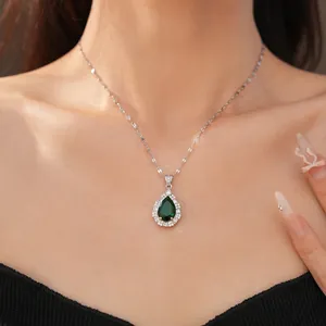 Close-up of a pear-cut green zircon pendant necklace with a halo of sparkling stones.