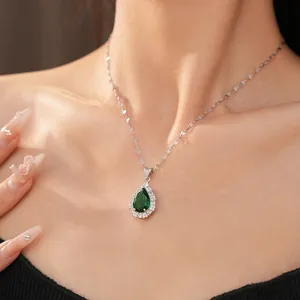Detail view of elegant pear-shaped emerald green zircon pendant necklace on model