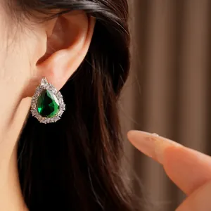 Detailed view of an elegant green zircon teardrop earring worn on a female ear lobe