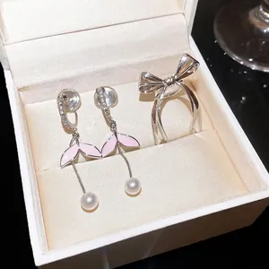 Elegante conjunto de pendientes de perla rosa y anillo de lazo plateado