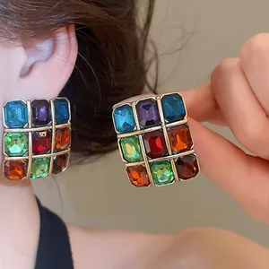 Close-up of vintage square earrings with colorful rectangular gemstones.