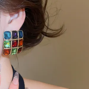 Macro view of vintage style square earrings featuring colorful multi-gemstone mosaic