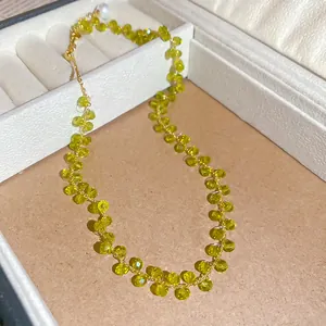 Makrodetail einer 14k vergoldeten Halskette mit gelbgrünen Kristallperlen