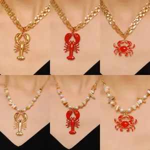 Detail view of ocean-themed lobster and crab pendants with gold chains and pearls