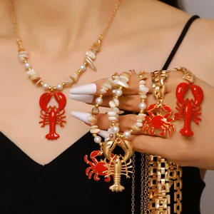 Close-up detail of red lobster and crab pendants with gold chains and faux pearls