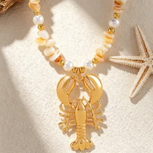 Close-up of gold lobster pendant necklace with bohemian shell beads and pearls for beach vacation.