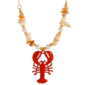Detailed view of red lobster pendant necklace with beach style shells and pearls
