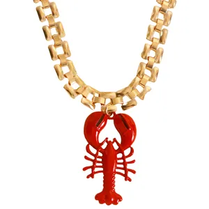 Macro view of a vibrant red lobster pendant on a chunky gold-toned chain necklace