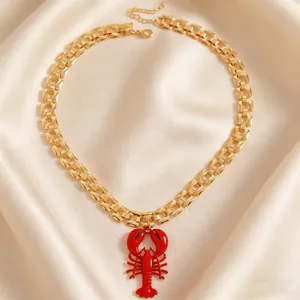 Close-up of a vibrant red lobster pendant on a chunky gold chain necklace