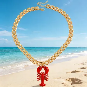 Close-up of vibrant red lobster pendant on a chunky gold link chain beach necklace