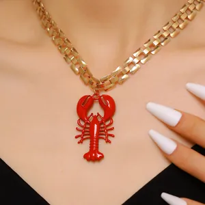 Detailed view of a red lobster pendant on a chunky gold chain necklace for beach vacation style
