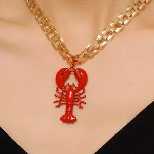 Detailed close-up of a vibrant red lobster pendant necklace on a gold metal chain for beach style