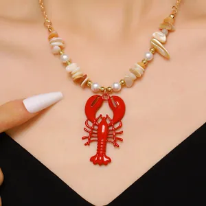 Detailed close-up of a vibrant red lobster pendant necklace with shell beads and pearls