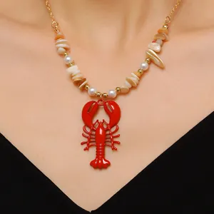 Detail of red lobster pendant necklace with shell beads and pearls for beach vacation.