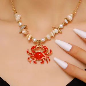 Detail shot of a red crab pendant necklace with sea shells and imitation pearls