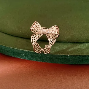Detailed view of a gold-plated hollow bow-knot open ring on a velvet background