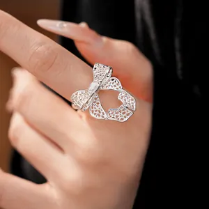 Detailed macro shot of a silver hollow bow-knot open ring with intricate mesh texture.