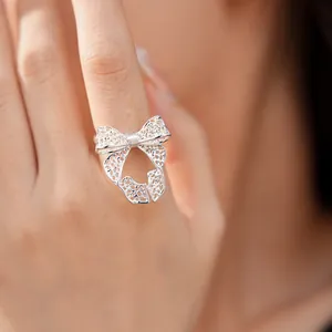 Detailed view of an elegant silver bow-shaped hollow filigree adjustable open ring for women