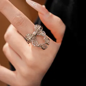 Detail view of a silver hollow bow open ring showing intricate filigree work