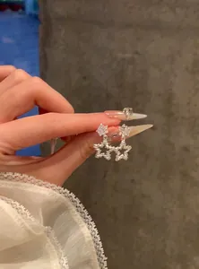 Close-up view of sparkling star-shaped zirconia earrings held by hand for detail display