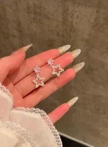 Close-up view of refined silver star earrings decorated with sparkling zircon stones