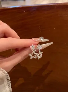 Detailed close-up view of sparkling silver star-shaped earrings with clear zircon stones