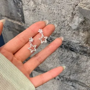 Macro view of sparkling zircon star stud earrings featuring a hollow star drop design