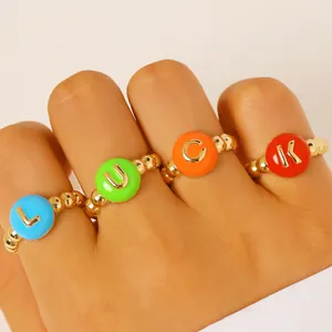 Primo piano di quattro anelli colorati con lettere LUCK dorate su una fascia di perle.