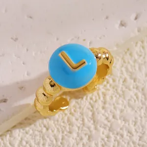 Primo piano dettagliato di perla blu con lettera L dorata su anello d'oro