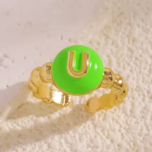 Primo piano di anello in smalto verde con lettera U dorata