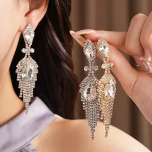 Détail de boucles d'oreilles pampilles gouttes avec strass étincelants en argent et or