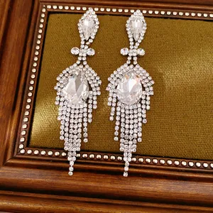 Gros plan d'élégantes boucles d'oreilles pendantes argentées avec strass brillants.