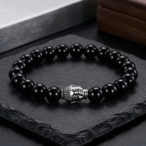 Detail of 10mm black polished beaded bracelet with a silver Buddha head charm on stone