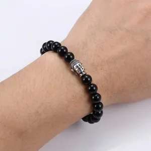 Detail of beaded bracelet featuring black glossy 10mm beads and a vintage silver Buddha head