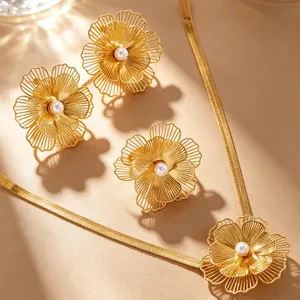 Detail view of gold hollow flower jewelry set with pearls, necklace and earrings